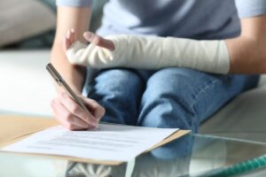 Injured woman with bandaged arm signing document
