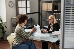 Young woman filling documents at insurance agency