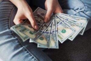 person holding several $100 bills