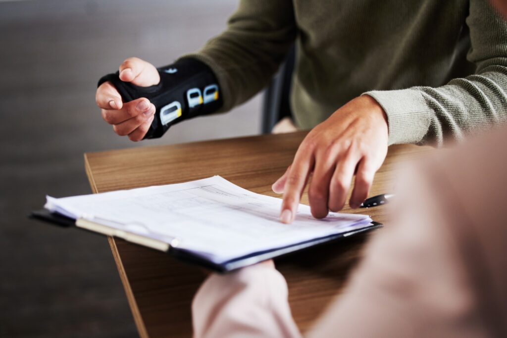 person with injured wrist pointing to legal document