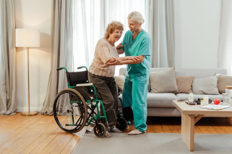 individual in a wheelchair being helped by a nurse in a nursing home