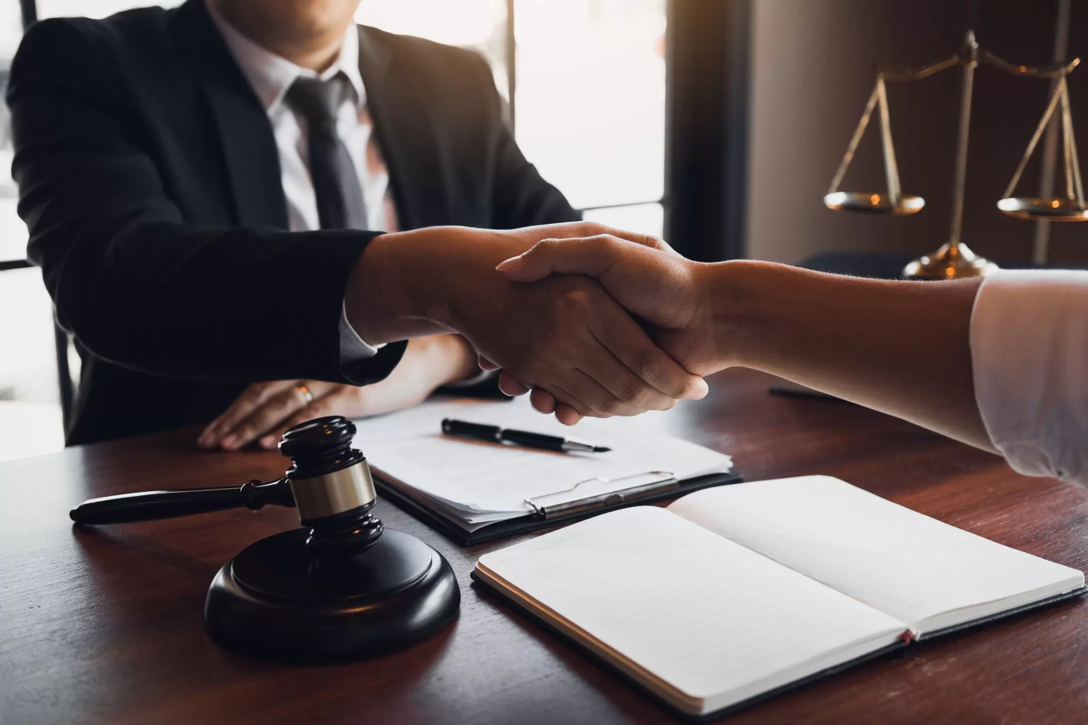 attorney shaking client's hand in law office