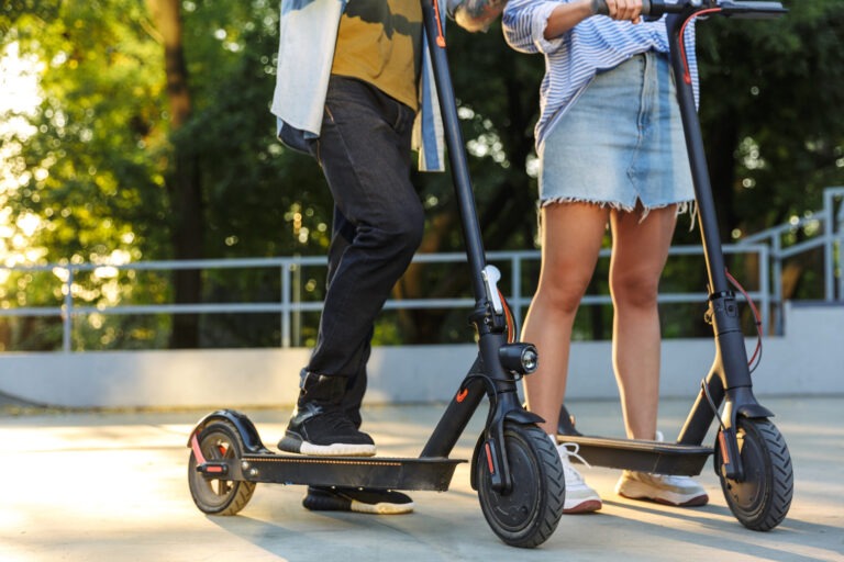 two people riding scooters