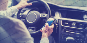 Man using a smartphone while driving a car, geometric pattern